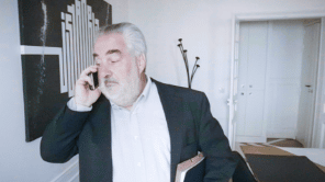Homme debout au téléphone avec un dossier sous le bras